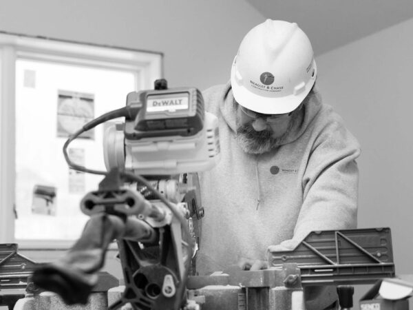 neagley and chase construction worker using chop saw